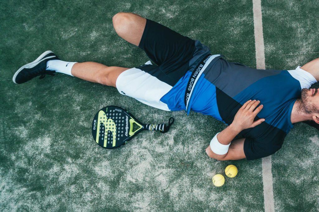 man laying down on a tennis court