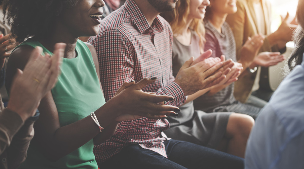 employees smiling and clapping for person being awarded