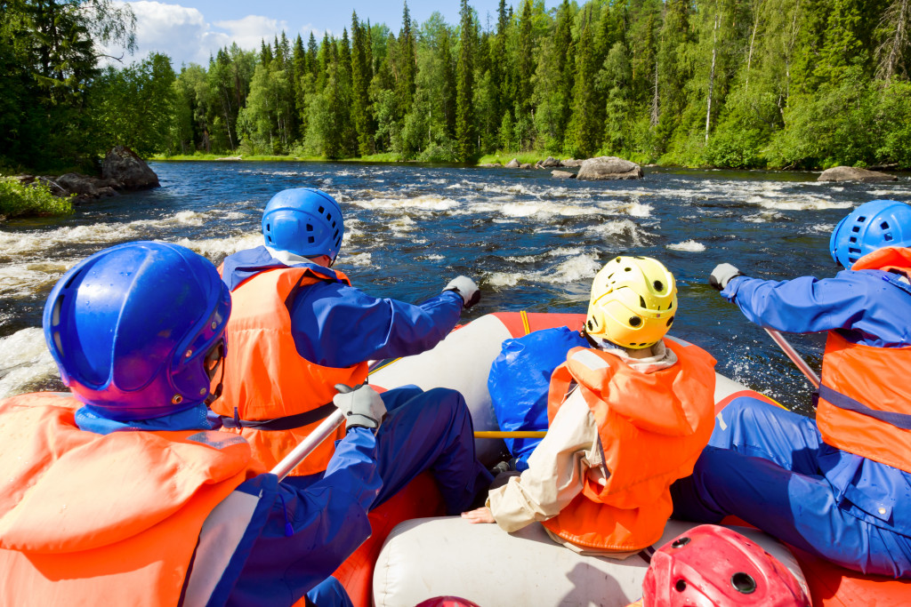 employees rafting through rapids in a river in nature