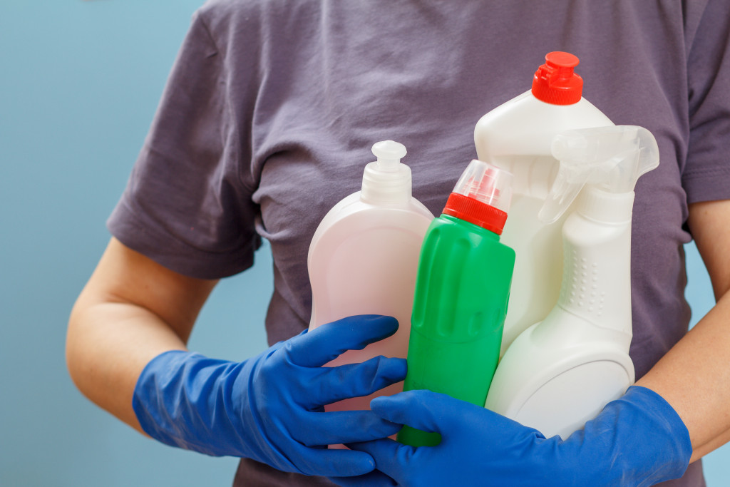 man holding cleaning products bleach concept