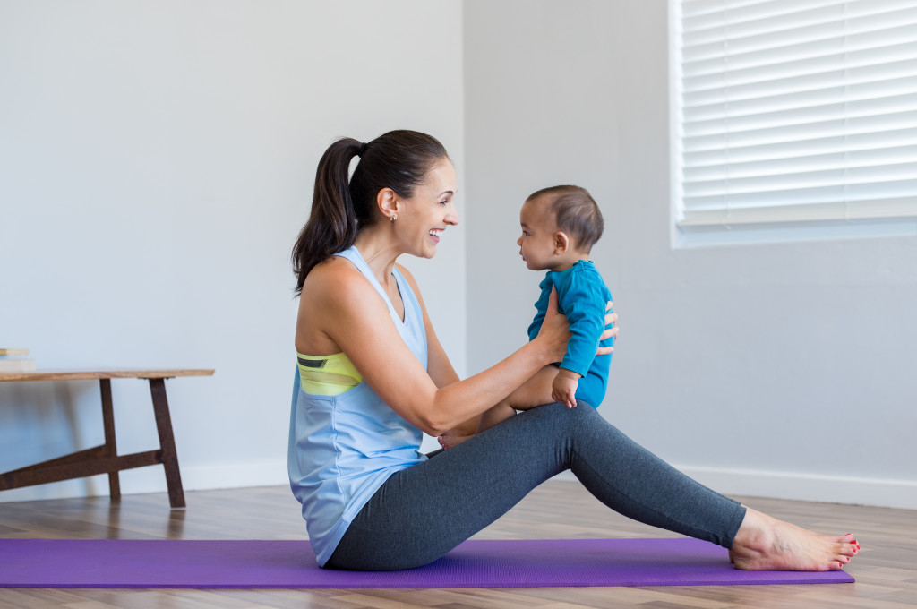 Mother exercising at home with her baby.